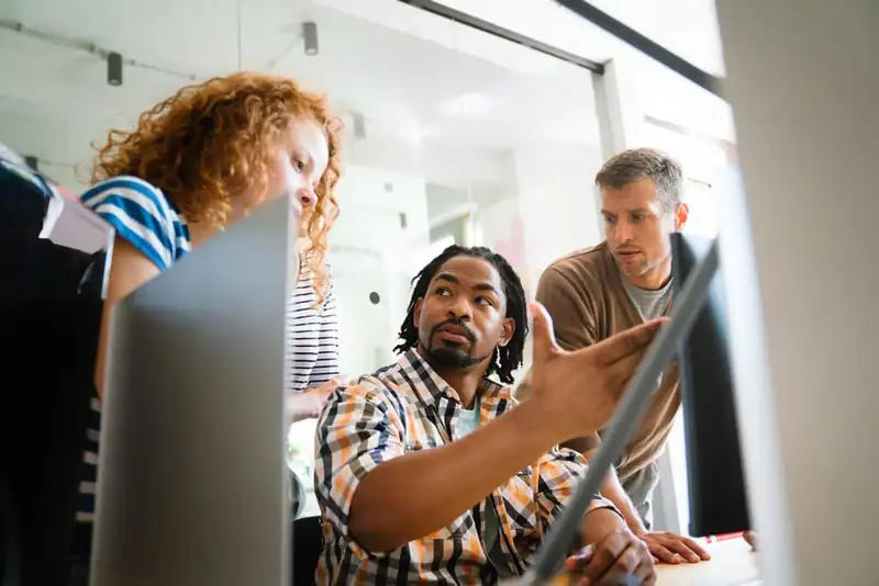 IT engineers reviewing code on screen together